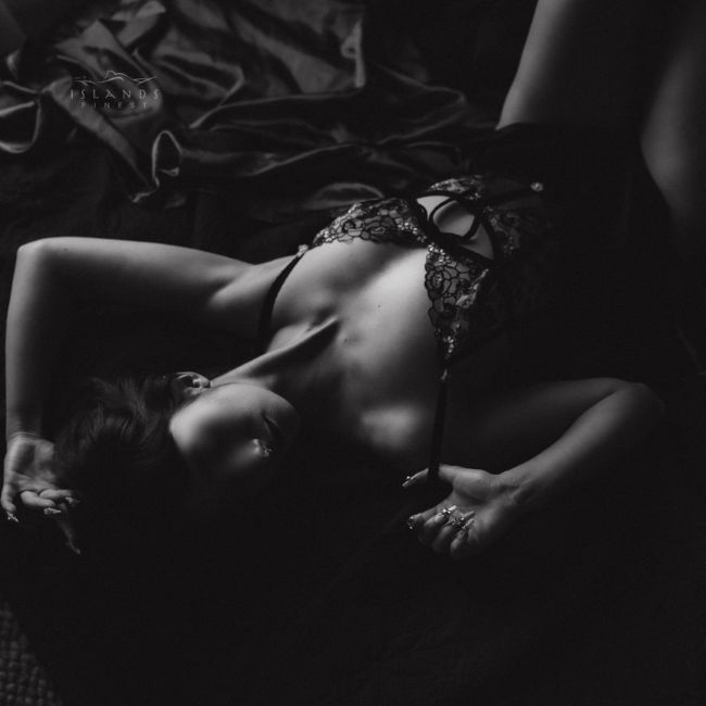 island's finest escort nyx laying back thumb hooked under lingerie strap in lacey one piece 650