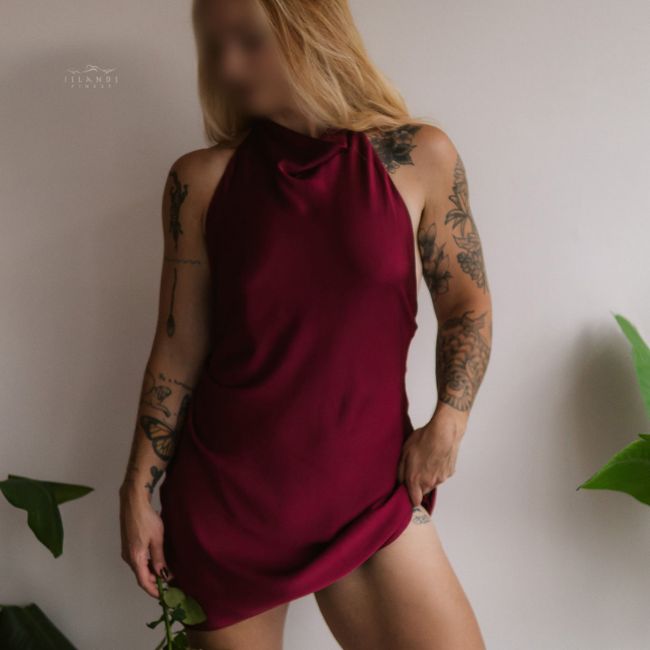 island's finest escort caroline wearing red silk dress holding white rose 650